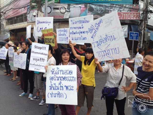 ชาวบ้านถือป้ายแสดงพลังต่อต้านตักบาตรพระหมื่นรูป