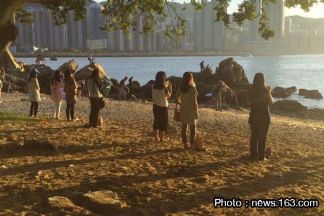 เทรนด์ใหม่ สาวฮ่องกงยืนจ้องดวงอาทิตย์  เชื่อลดอ้วน