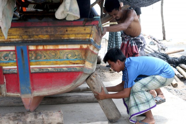 ชาวประมงบ้านปาตา เร่งลากเรือกอและขึ้นที่สูง หลังถูกคลื่นซัดเสียหายหนัก