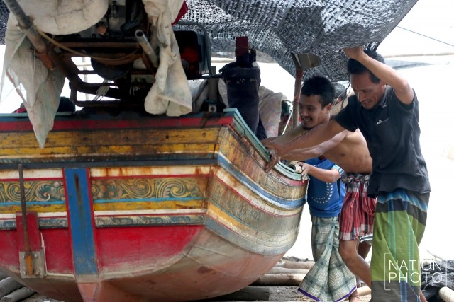 ชาวประมงบ้านปาตา เร่งลากเรือกอและขึ้นที่สูง หลังถูกคลื่นซัดเสียหายหนัก