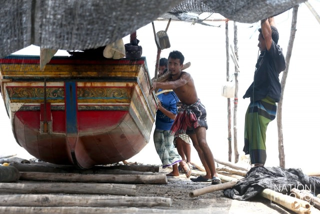 ชาวประมงบ้านปาตา เร่งลากเรือกอและขึ้นที่สูง หลังถูกคลื่นซัดเสียหายหนัก