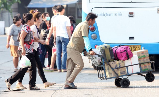 ประชาชนขนสัมภาระลงทางรถทัวร์ หลังจากเดินทางกลับจากต่างจังหวัด ที่หมอชิต