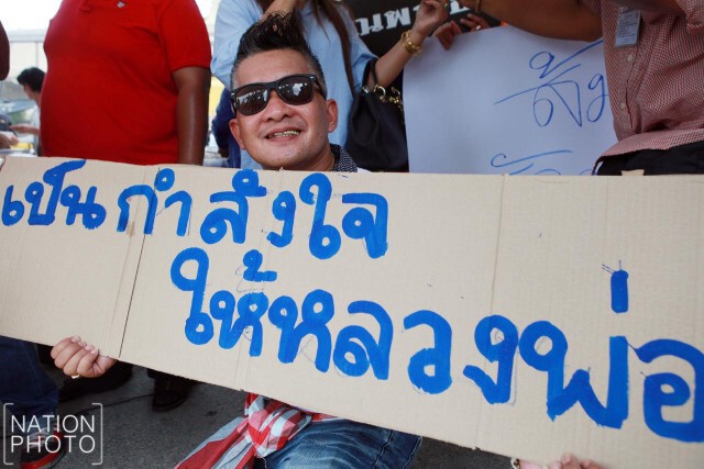 ชาวบ้านคลองสามที่สนับสนุนวัดธรรมกาย ถือป้ายให้กำลังใจ "ธัมมชโย"