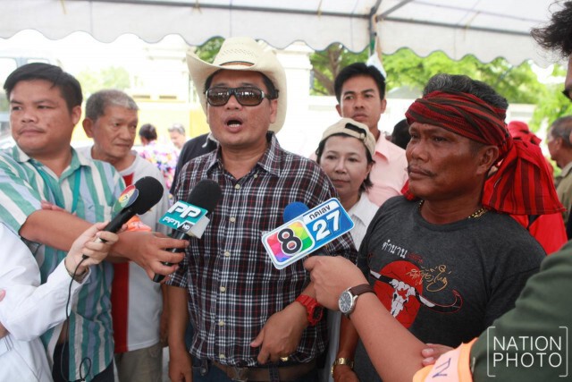ชาวบ้านคลองสามที่สนับสนุนวัดธรรมกาย ถือป้ายให้กำลังใจ "ธัมมชโย"