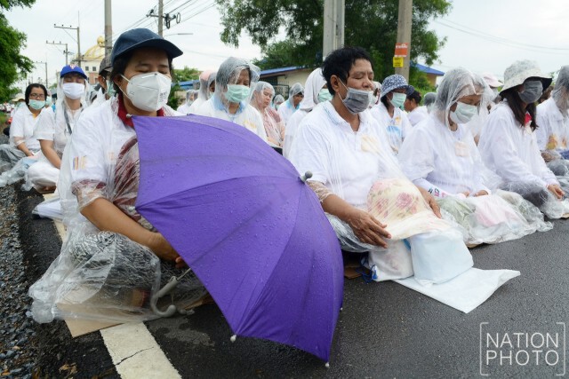 ลูกศิษย์ธรรมกาย นั่งสวดมนต์กลางสายฝน ให้กำลังใจธัมมชโย