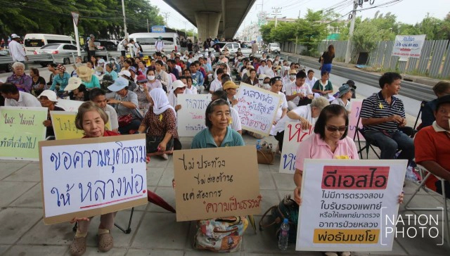 ศิษย์วัดธรรมกาย ถือป้ายให้กำลังใจ "ธัมมชโย"