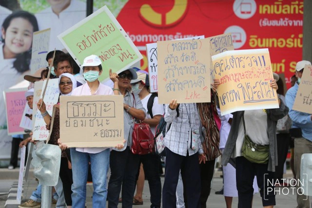 ศิษย์วัดธรรมกาย ถือป้ายให้กำลังใจ "ธัมมชโย"