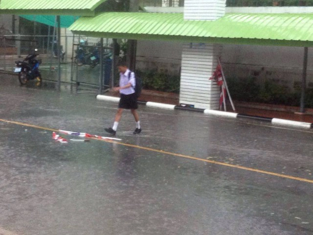 "ธงชาติเป็นของสูง" 
เด็กชายฝ่าสายฝนเก็บธงไตรรงค์เปิดใจ