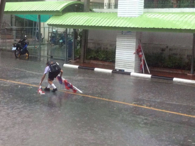 "ธงชาติเป็นของสูง" 
เด็กชายฝ่าสายฝนเก็บธงไตรรงค์เปิดใจ