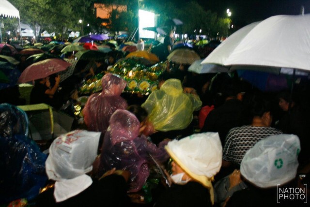 ประชาชนยังคงเฝ้ารอการจุดเทียน ในเวลา 22.00 น. แม้มีฝนตกลงมาที่ท้องสนามหลวง
