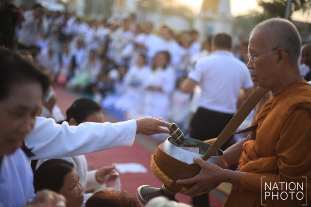 ชาวนครพนมทำบุญตักบาตร หลังเสร็จสิ้นพิธีปฏิบัติบูชาพระธาตุพนมข้ามคืน ปี 2559