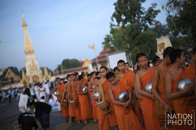 ชาวนครพนมทำบุญตักบาตร หลังเสร็จสิ้นพิธีปฏิบัติบูชาพระธาตุพนมข้ามคืน ปี 2559