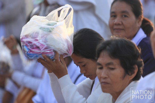 ชาวนครพนมทำบุญตักบาตร หลังเสร็จสิ้นพิธีปฏิบัติบูชาพระธาตุพนมข้ามคืน ปี 2559