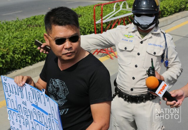 หนุ่มสกลนคร ยืนถือป้ายหน้า"ธรรมกาย"
ล้อเลียน"ธัมมชโย"
"กลัวทำไมแค่หมายจับ"