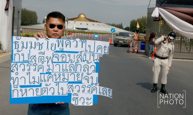 หนุ่มสกลนคร ยืนถือป้ายหน้า"ธรรมกาย"
ล้อเลียน"ธัมมชโย"
"กลัวทำไมแค่หมายจับ"