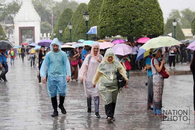 สายฝนโปรยปรายทั่วกทม.
นทท.ยืนกางร่มหลบฝนที่วัดพระแก้ว