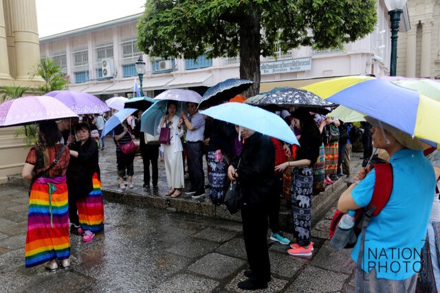 สายฝนโปรยปรายทั่วกทม.
นทท.ยืนกางร่มหลบฝนที่วัดพระแก้ว