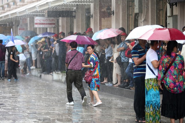 สายฝนโปรยปรายทั่วกทม.
นทท.ยืนกางร่มหลบฝนที่วัดพระแก้ว