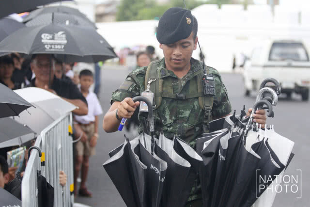 ทหารนำร่มมาให้ประชาชน ก่อนเข้ากราบสักการะพระบรมศพ ร.9