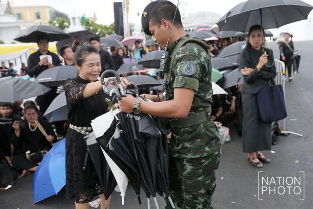 ทหารนำร่มมาให้ประชาชน ก่อนเข้ากราบสักการะพระบรมศพ ร.9