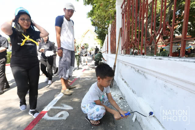 อาสาสมัครโครงการ "ทำดีถวายพ่อหลวง" ทาสีกำแพงวัดให้ดูสะอาด เตรียมพร้อมสำหรับงานพระราชพิธีฯ