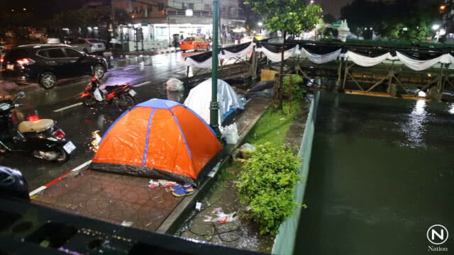 ประชาชนปักหลักนอนรอในท้องสนามหลวงตั้งแต่คืน 23 ต.ค. แม้ฝนตกก็ไม่ถอย