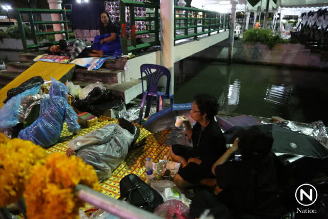 ประชาชนปักหลักนอนรอในท้องสนามหลวงตั้งแต่คืน 23 ต.ค. แม้ฝนตกก็ไม่ถอย