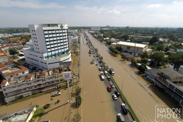 ภาพมุมสูง สภาพน้ำป่าจากแม่น้ำเพชร เอ่อล้นตลิ่งเข้าท่วมถนนเพชรเกษมช่วงผ่านตัวเมืองเพชรบุรี