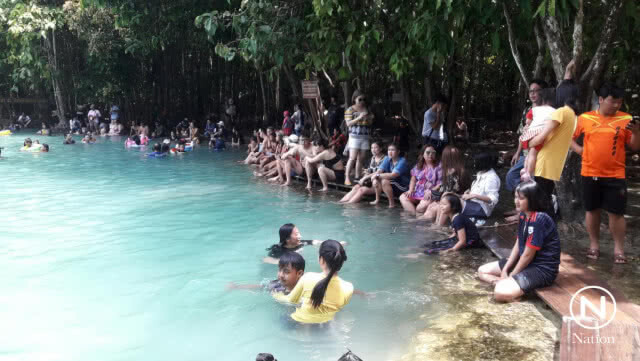 พบนักท่องเที่ยว ขีดเขียนโขดหินขอบสระมรกต