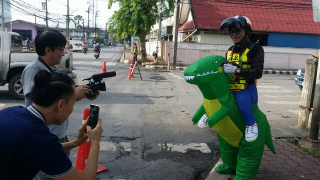 ตำรวจจราจรแต่งชุดไดโนเสาร์โบกรถ สร้างสีสันให้เด็กๆ
