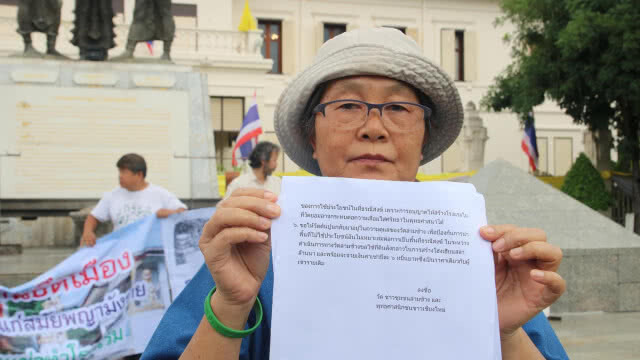 กลุ่มเครือข่ายชุมชนเมืองรักเชียงใหม่ ถือป้ายประท้วงนำพื้นที่่วัดเก่าทำโรงแรม