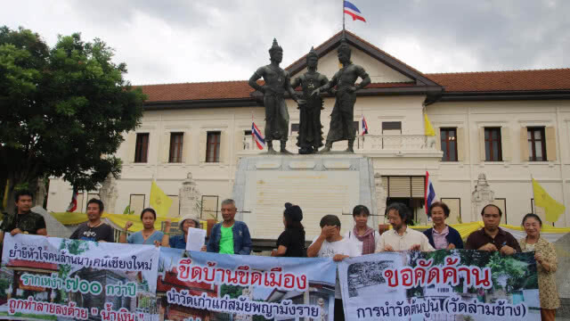 กลุ่มเครือข่ายชุมชนเมืองรักเชียงใหม่ ถือป้ายประท้วงนำพื้นที่่วัดเก่าทำโรงแรม