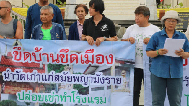 กลุ่มเครือข่ายชุมชนเมืองรักเชียงใหม่ ถือป้ายประท้วงนำพื้นที่่วัดเก่าทำโรงแรม