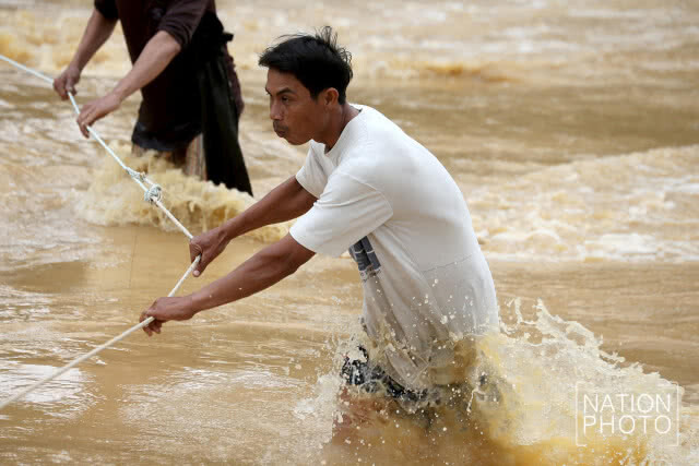 ชาวท่าแซะไต่เชือก ลุยน้ำท่วมรับของบริจาค