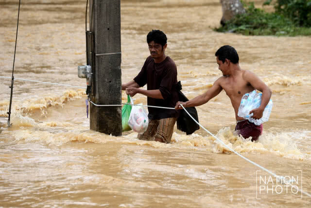ชาวท่าแซะไต่เชือก ลุยน้ำท่วมรับของบริจาค