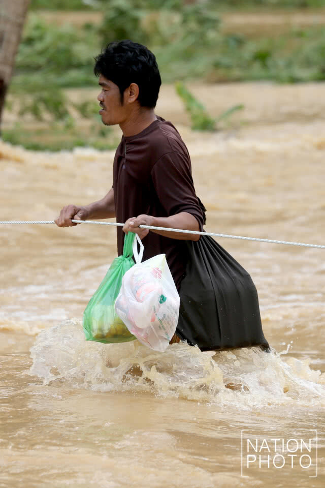 ชาวท่าแซะไต่เชือก ลุยน้ำท่วมรับของบริจาค