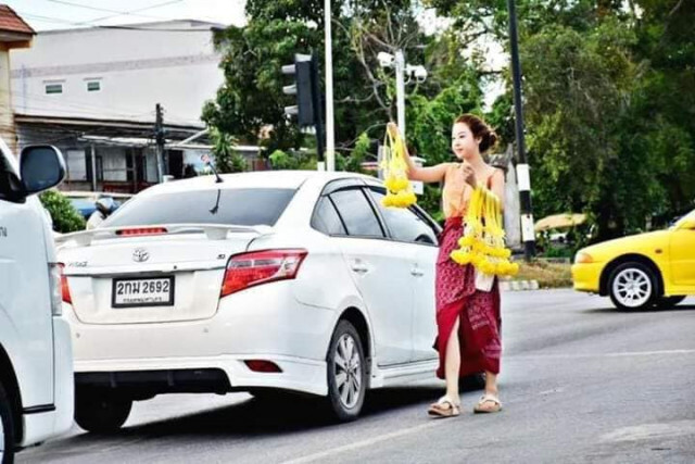 ตะลึงทั้งแยกไฟแดง!! สาวหน้าตาดีสวมชุดไทย ยืนขายพวงมาลัย
