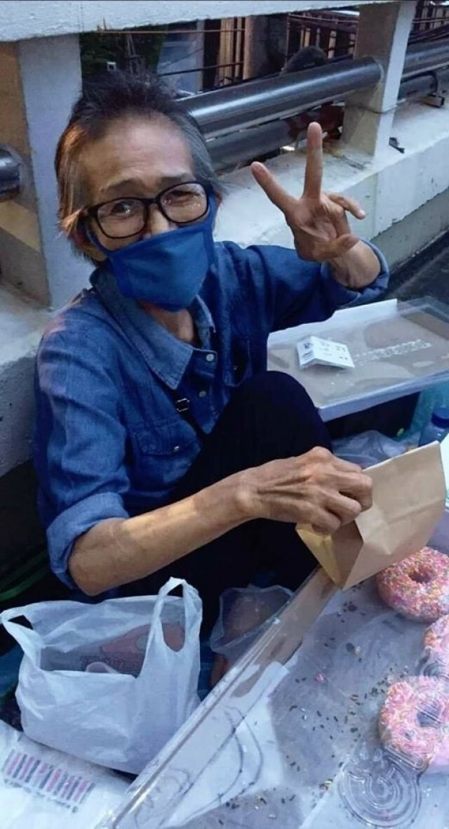 หญิงชรานั่งขายขนมบนสะพานลอย หาเงินซื้อยารักษาตัว