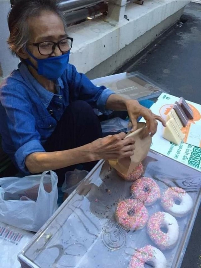 หญิงชรานั่งขายขนมบนสะพานลอย หาเงินซื้อยารักษาตัว