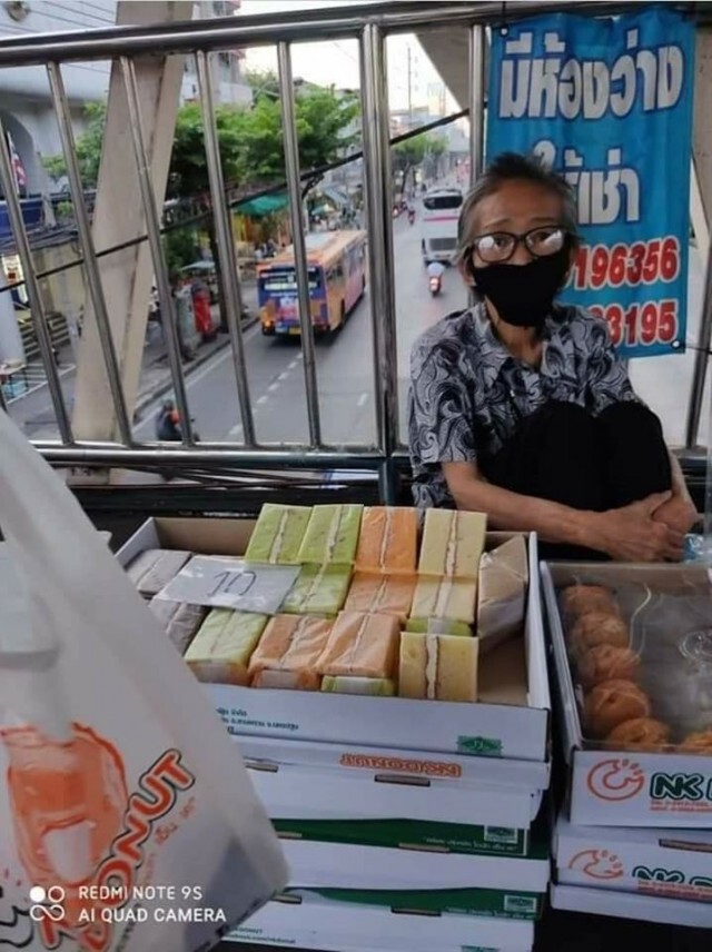 หญิงชรานั่งขายขนมบนสะพานลอย หาเงินซื้อยารักษาตัว