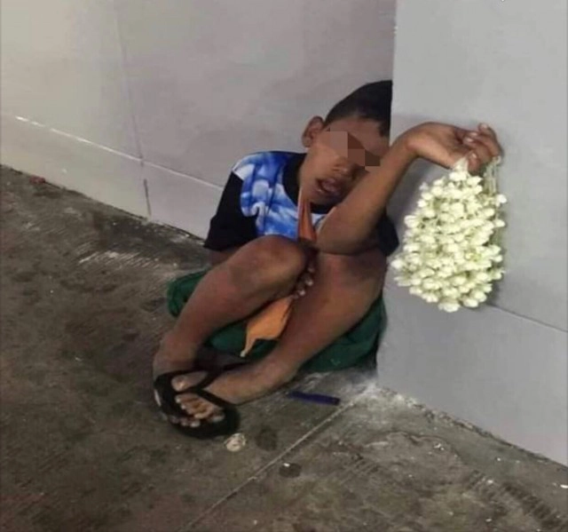 หนุ่มสะเทือนใจเห็นเด็กขายพวงมาลัย เหนื่อยหลับคากำแพง มือประคองดอกไม้