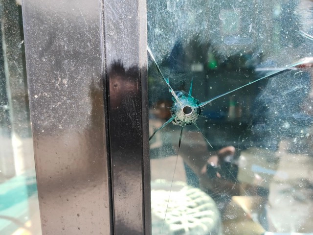 ตำรวจตรวจรอยกระสุนทะลุกระจกร้านตัดผม