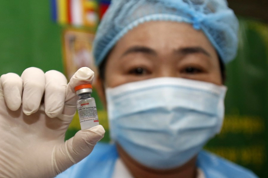 แฟ้มภาพซินหัว : บุคลากรการแพทย์ถือขวดวัคซีนป้องกันโรคโควิด-19 ณ ศูนย์ฉีดวัคซีนในกรุงพนมเปญ เมืองหลวงของกัมพูชา วันที่ 17 ก.ย. 2021