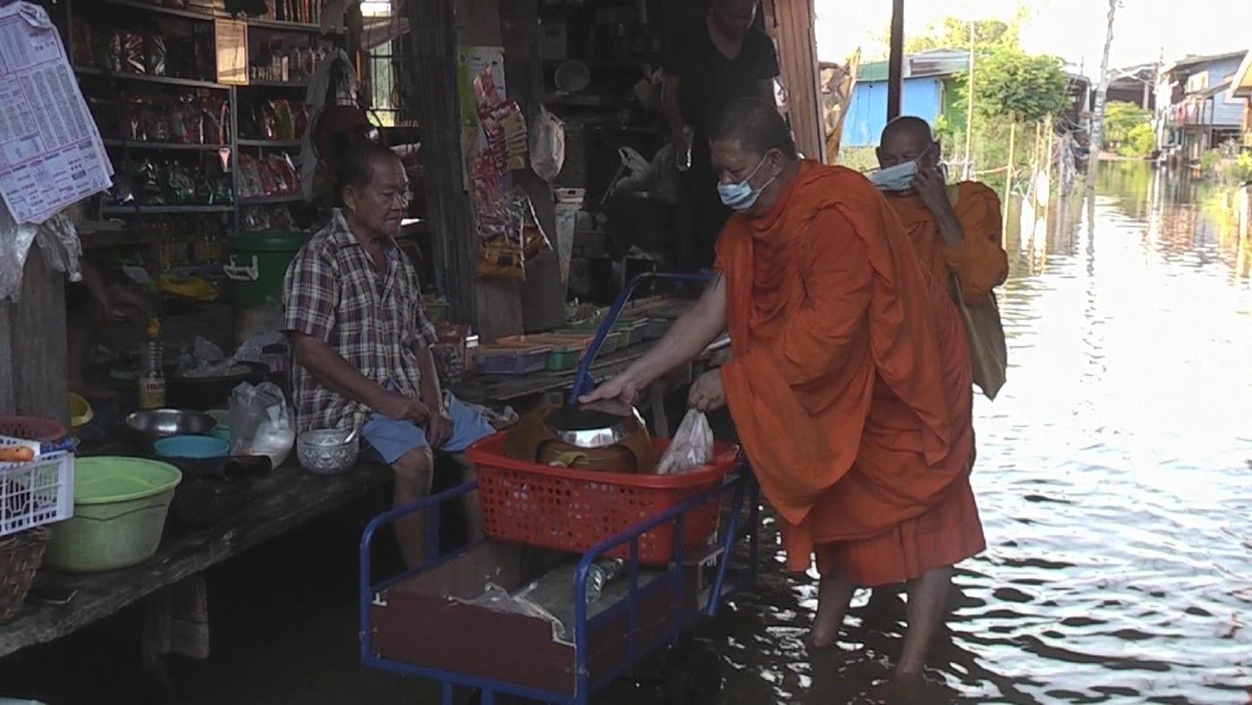 พระจังหวัดพิจิตรเดินลุยน้ำท่วมบิณฑบาต