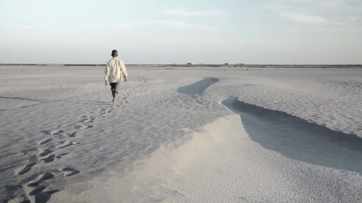 จาดาฟ ปาเยง กำลังเดินบนผืนทรายที่ว่างเปล่าบนเกาะมาจูลี