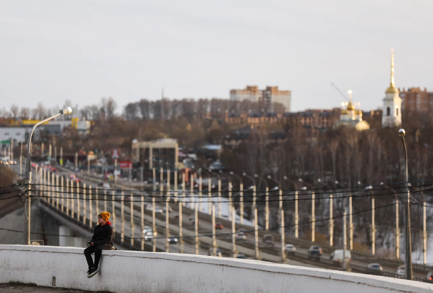 วัยรุ่นนั่งบนเชิงเทินที่จุดชมวิวใน Kaluga