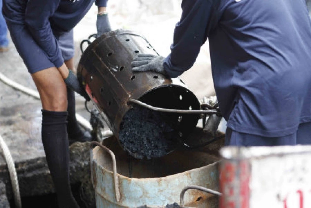 ภาพของผู้ต้องขังชั้นทีที่ทำหน้าที่ลอกท่อระบายน้ำกันน้ำท่วม