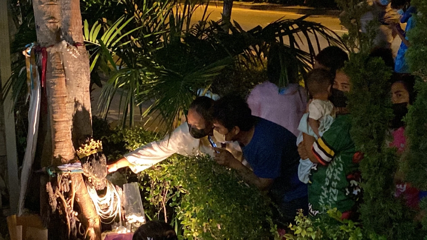 คอหวยแห่ขอโชคพี่สาว ตุ๊กตาไม้ ใต้ต้นโพธิ์หน้าร้านอาหารริมถนนเลียบด่วน