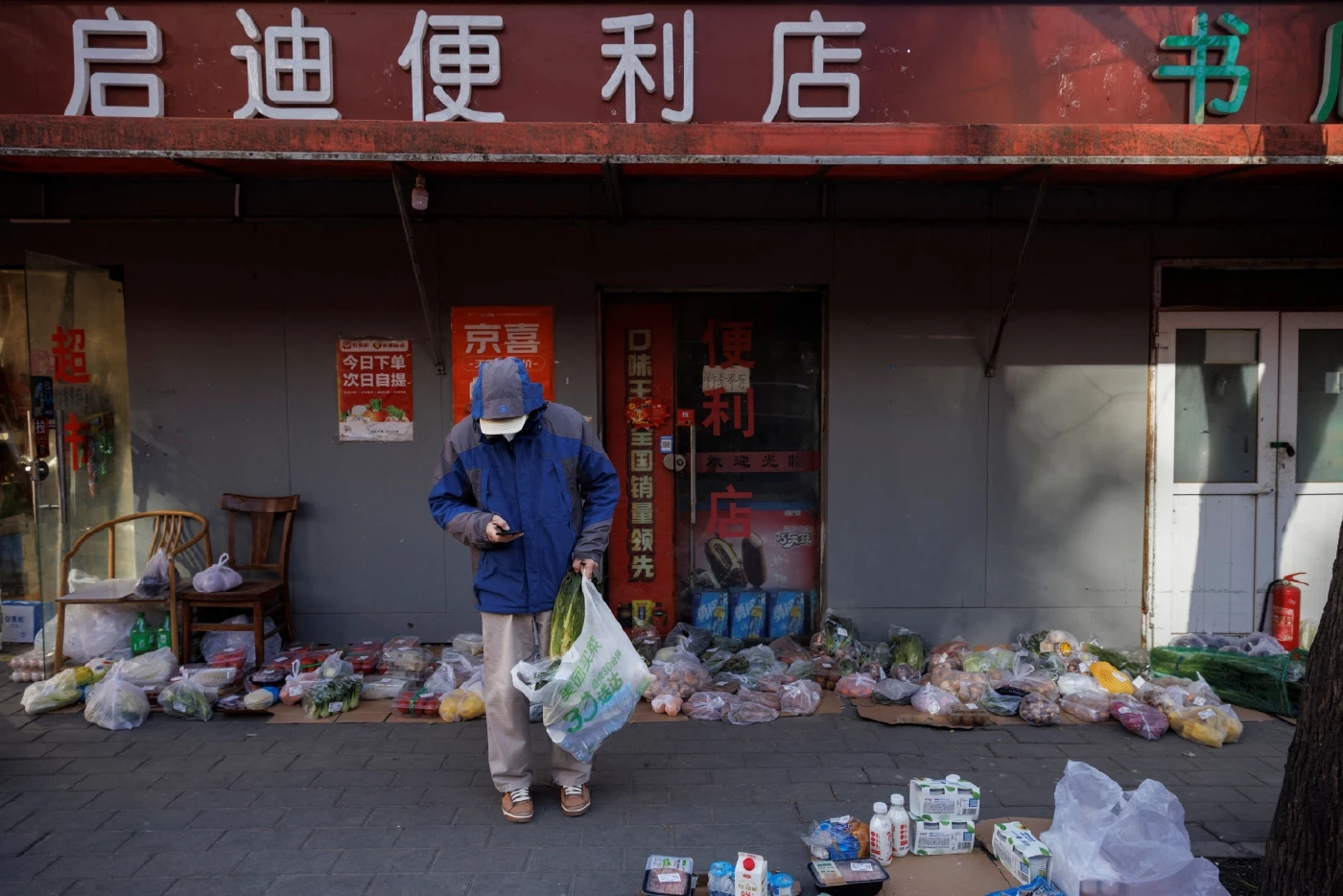 ลูกค้าเลือกถุงสินค้าที่สั่งซื้อไว้ เนื่องจากร้านค้าในปักกิ่งยังคงปิดเพราะมาตรการควบคุมโควิด