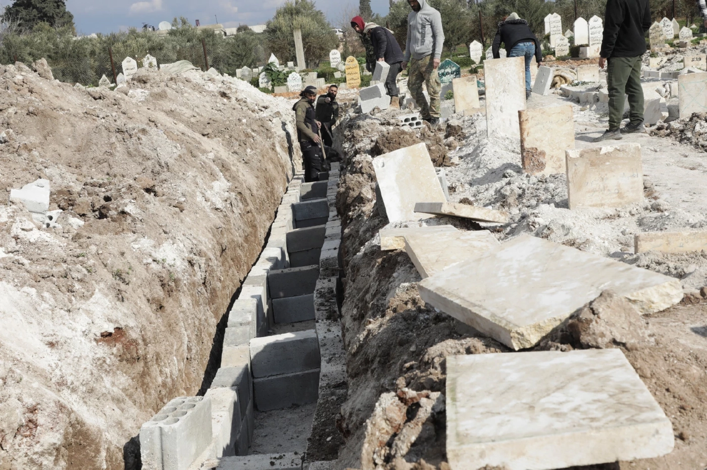 อาสาสมัครขุดหลุมเพื่อเตรียมฝังศพเหยื่อแผ่นดินไหวในเมืองจันดาริส